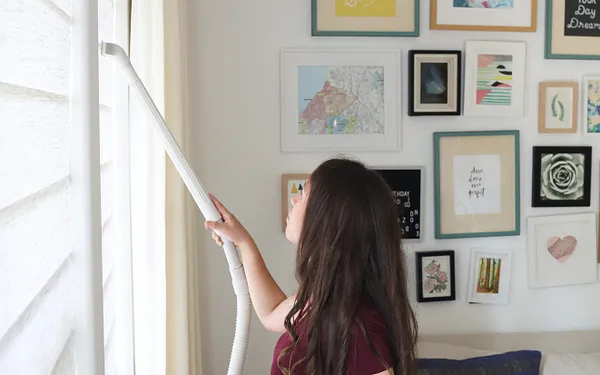 Vệ sinh rèm cửa tổ ong bằng hút bụi nhẹ trong phòng khách để hạn chế bụi và mùi ẩm